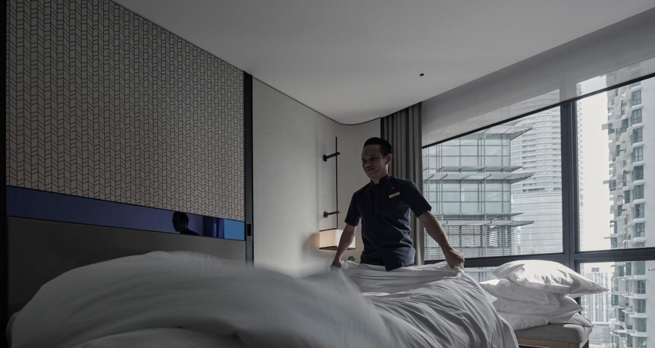 Amari Kuala Lumpur Exterior foto A hotel housekeeper making a bed